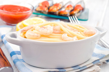 white porcelain pot with spaghetti and shrimps