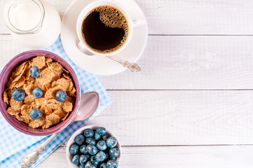 healthy breakfast, coffee cornflakes berries and milk, with text space top view close-up