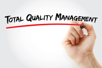 Hand writing Total Quality Management with marker, concept background