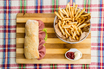 Ham sandwich with fried potatoes, ketchup and mayonnaise.