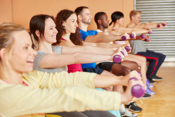 Gruppe trainiert mit Hanteln im Kurs