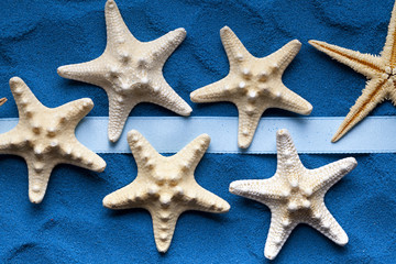 Fototapeta na wymiar Starfish and ribbon on blue background