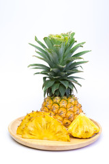 Pineapple fruit cut on wooden plate on white background