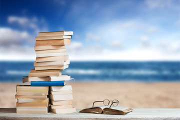 Stack of Travel Guides before a empty Beach