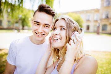 Fototapeta premium cheerful young couple having fun in the summer park..big headphones