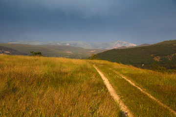 red sunset over green field with road