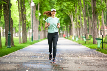 Full length portrait of a female runner running in the park.