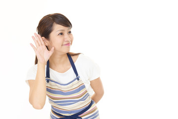 耳に手を当てる女性