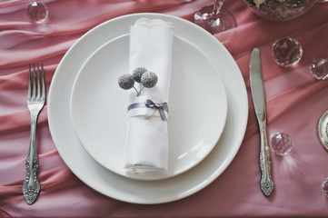 The plates and his knife and fork down on the table before dinne