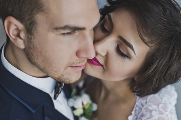 Naklejka premium The young husband and wife gently kiss each other on the backgro