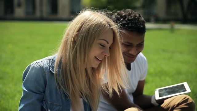 Interacial couple of students discussing outdoors