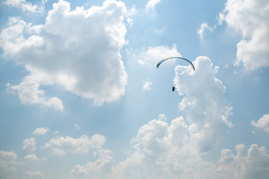 Paraglider in the blue sky, big blue clouds