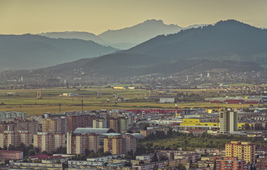 Early morning aerial cityscape of residential districts and suburbs of the Brasov city, the 7th largest city and most visited in Romania.