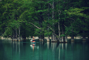 Explorer man kayaking on lake