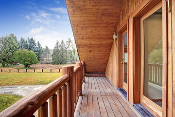 American log cabin house exterior. Landscape view from the balcony.