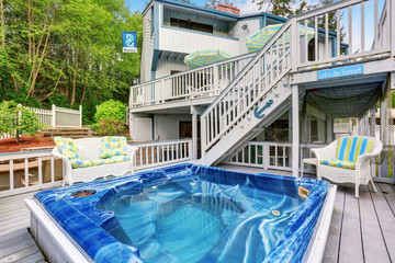 Large marine style home with two level deck. Jacuzzi view - obrazy, fototapety, plakaty