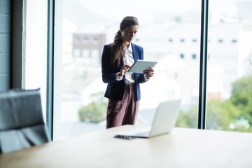 Focused woman using digital tablet in office