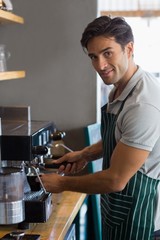 Waiter making cup of coffee at cafe