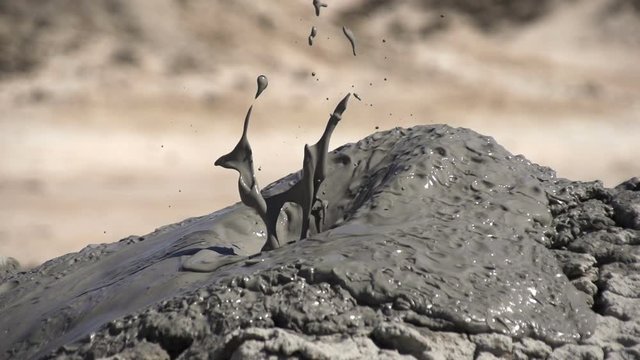A natural phenomenon called a mud volcano. Small geysers of mud erupt from the ground to form little volcano.