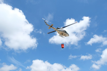 Firefighter helicopter flying with bambi bucket.