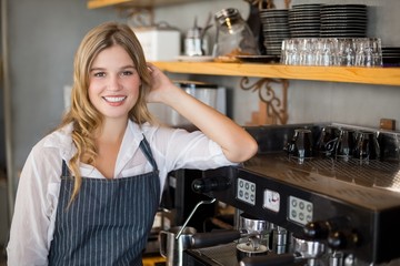 Fototapeta na wymiar Portrait of smiling waitress making cup of coffee