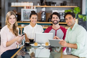 Group of friends using mobile phone, digital tablet and laptop