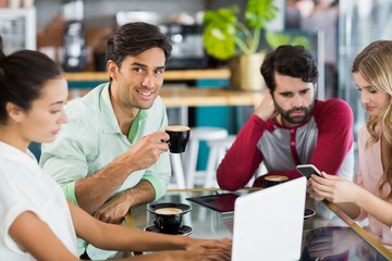 Group of friends using mobile phone and laptop