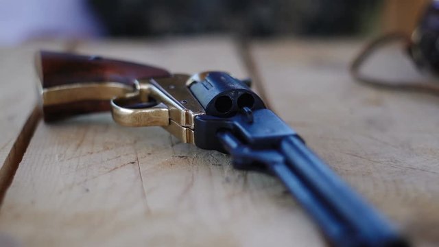 Duplicate of the Colt Peacemaker lying on a wooden table, the legendary American gun during the civil war.
