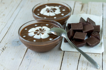 Шоколадный пудинг со взбитыми сливками на деревянном фоне