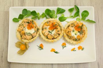 Salmon baked tartlet with mozzarella on a white plate