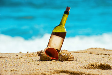 Alcohol wine bottle in the sand on a tropical beach