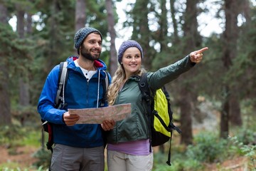 Hiker couple looking at map and pointing away