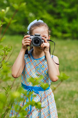 A girl taking picture in green bushes