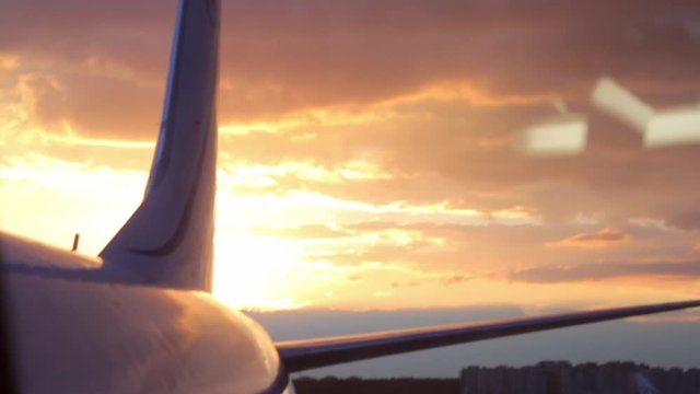 View of airplane in the airport against background with beautiful sunset.