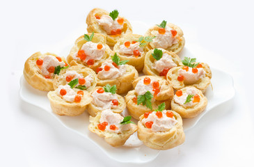 Profiteroles with mousse or pate and red caviar on white background