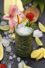 Tropical cocktails served in a tiki style glass and garnished with fruits and ice