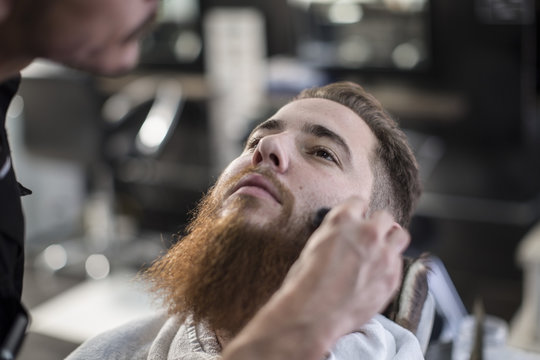 Barber brushing customers side hairs