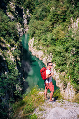 Man standing on mountain cliff over the river