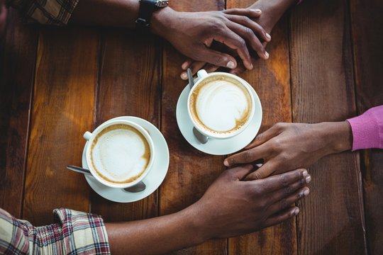 Couple Holding Hands While Having Coffee