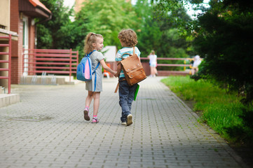 Young students, boy and girl, going to school