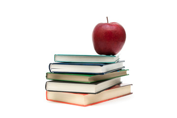 stack of books and red apple on a white background
