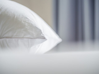 Closeup of white pillow on the bed in the bedroom