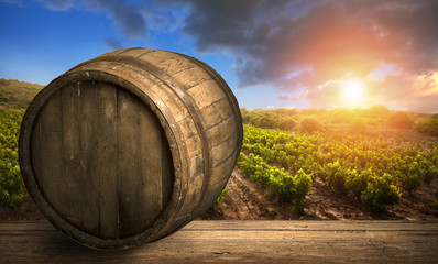 Red wine with barrel on vineyard in green Tuscany, Italy
