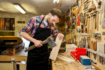 Fototapeta premium carpenter with ax and board working at workshop