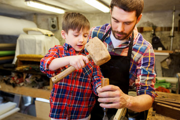 father and son with chisel working at workshop