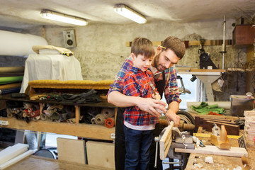 father and son with chisel working at workshop