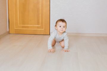 Little baby boy crawling on the floor at home