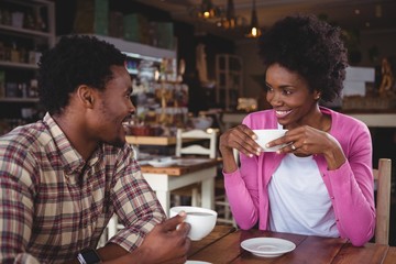 Young couple interacting with each other in cafeteria