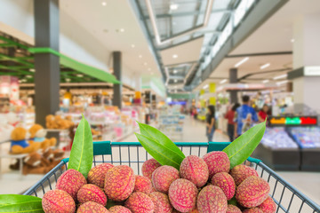ripe litchi fruits in shopping trolley in supermarket © Soonthorn