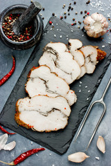 Chicken pastrami with pepper and garlic on a stone plate